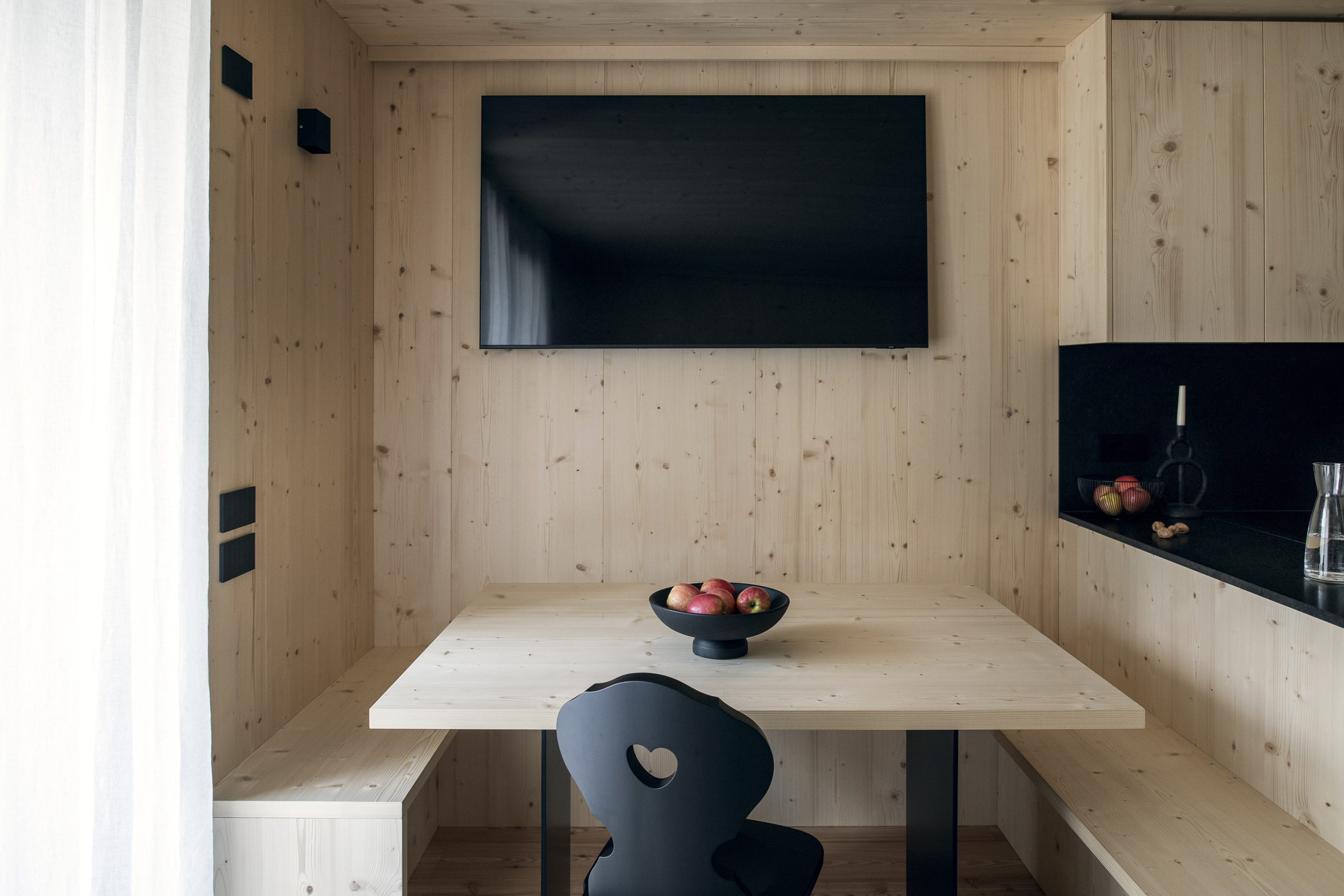 Sala da pranzo su misura Corazzolla in stile alpino con rivestimenti, panca e tavolo in legno di abete bianco inserita in una nicchia a Madonna di Campiglio