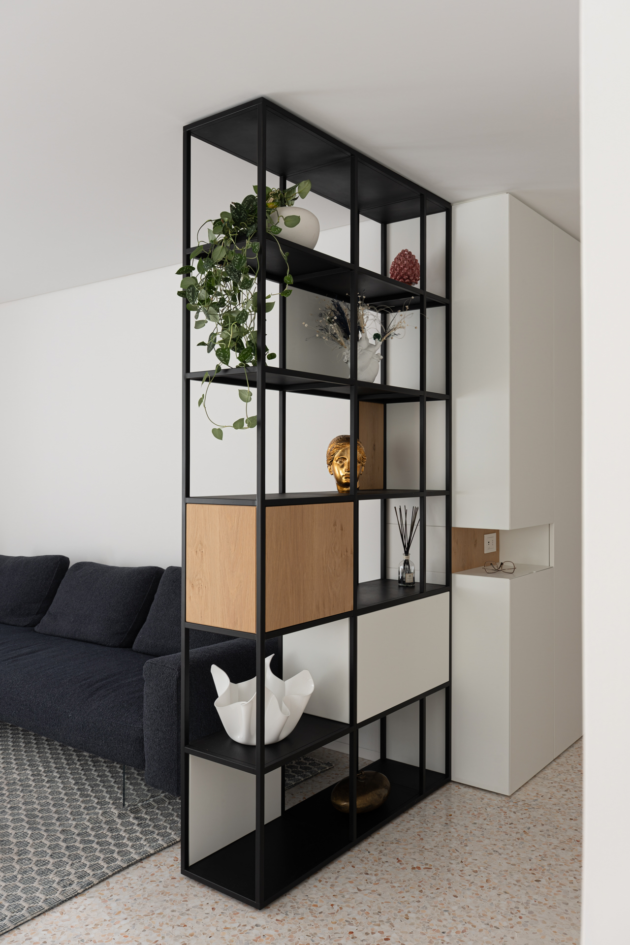 Libreria divisoria su misura realizzata da Corazzolla in ferro e legno. Soluzione di design moderno per separare zona giorno e zona notte con leggerezza visiva e funzionalità.