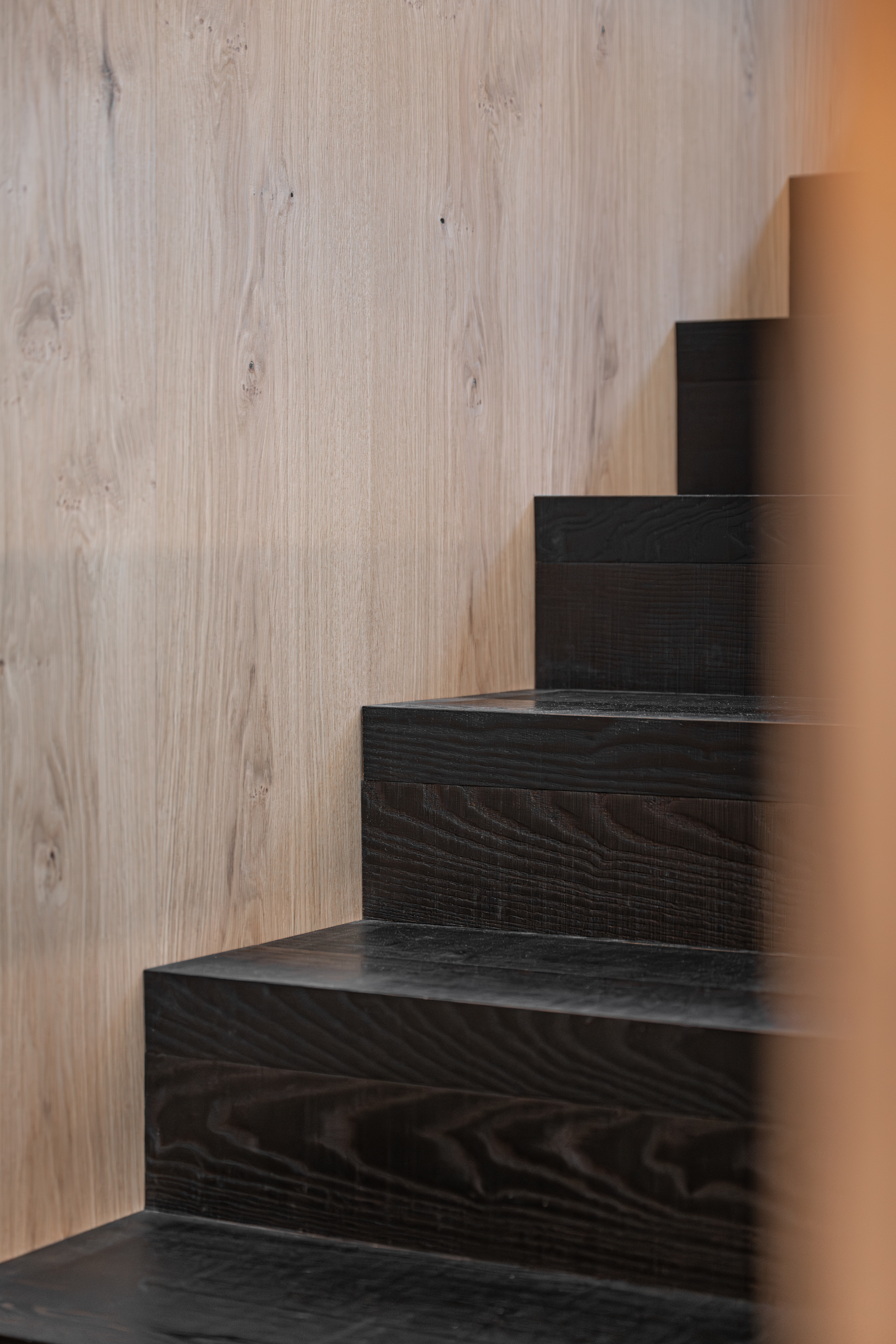 scala su misura in legno scuro di frassino termocotto con rivestimento in legno di rovere, realizzazione Corazzolla