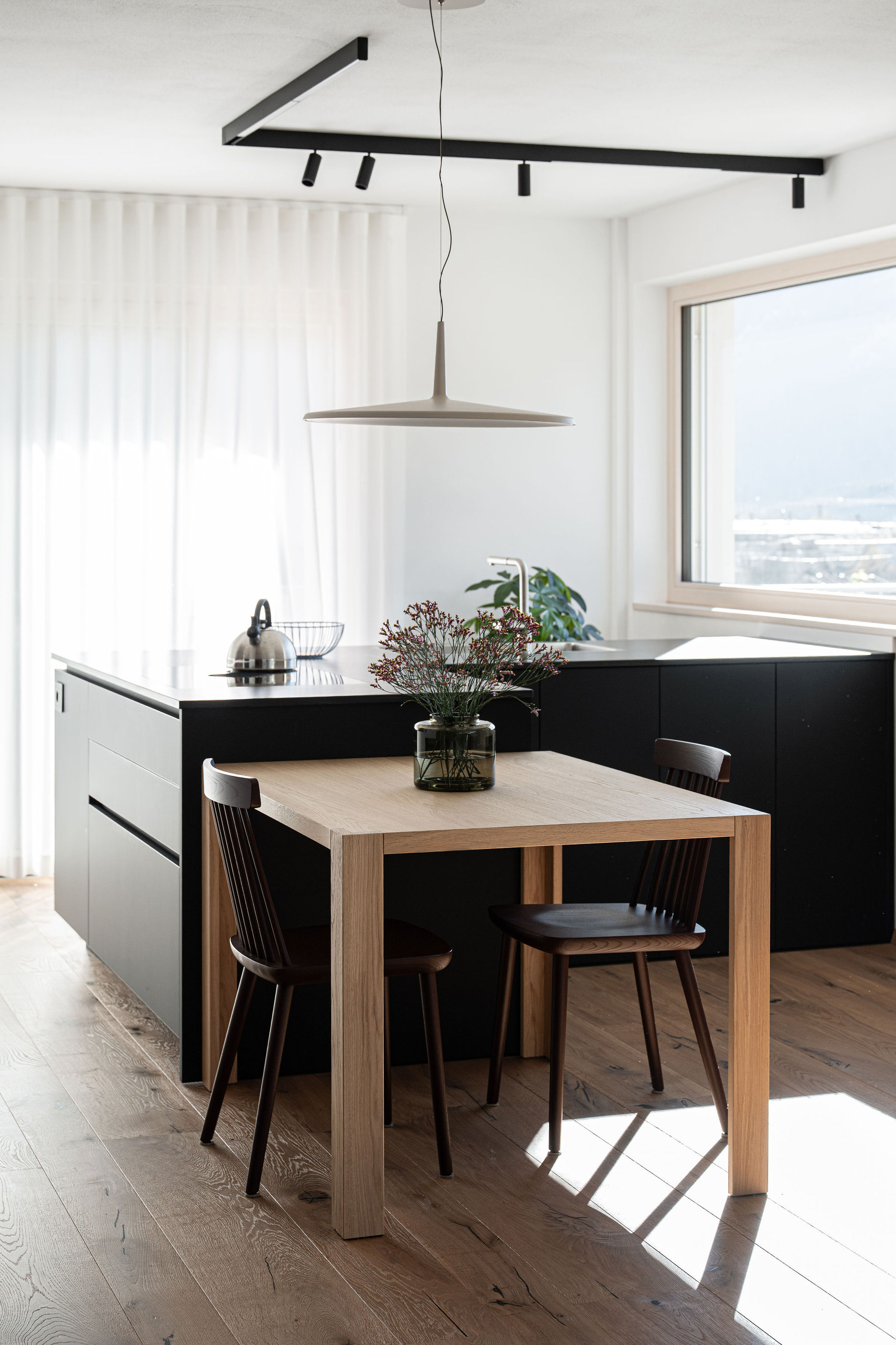 Cucina su misura minimale con isola a L nera, realizzata da Corazzolla