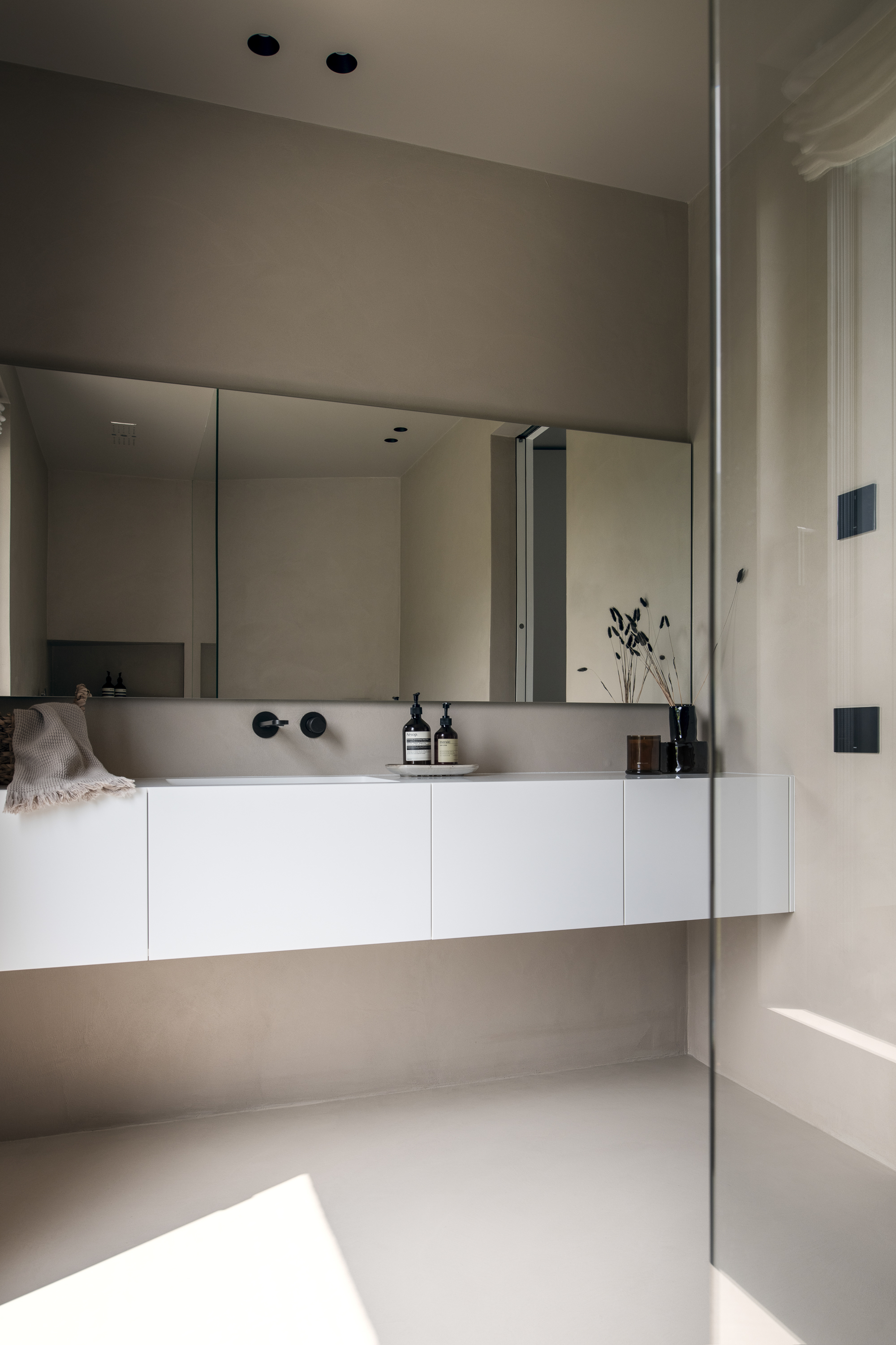 Bagno elegante con piano e lavabo integrato in Krion e superfici continue in resina, realizzazione su misura Corazzolla