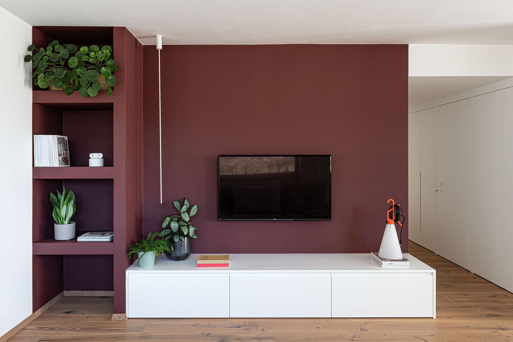 parete tv colorata con nicchie e mobile tv bianco da appoggio, realizzazione Corazzolla