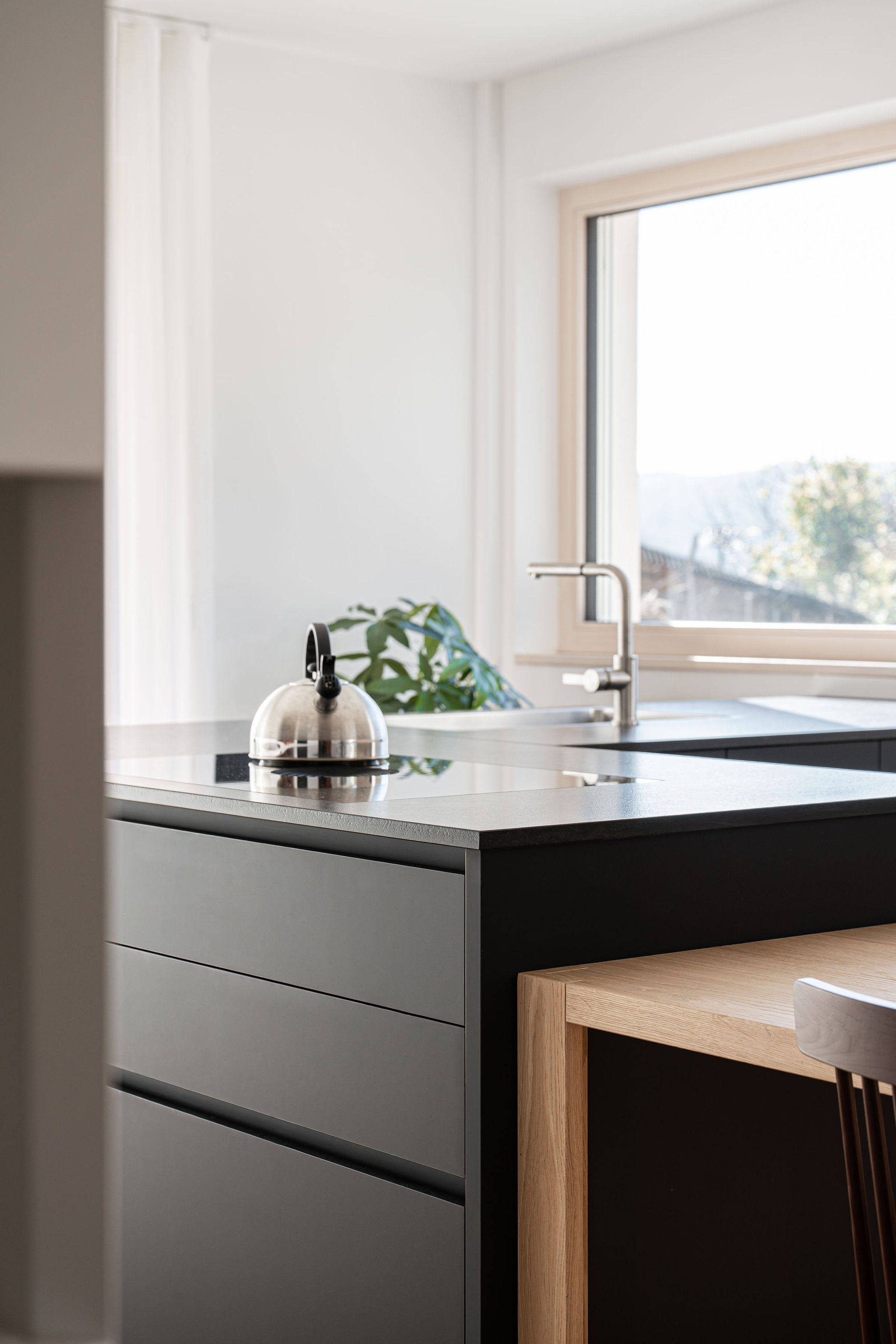 Cucina su misura minimale con isola a L nera, realizzata da Corazzolla