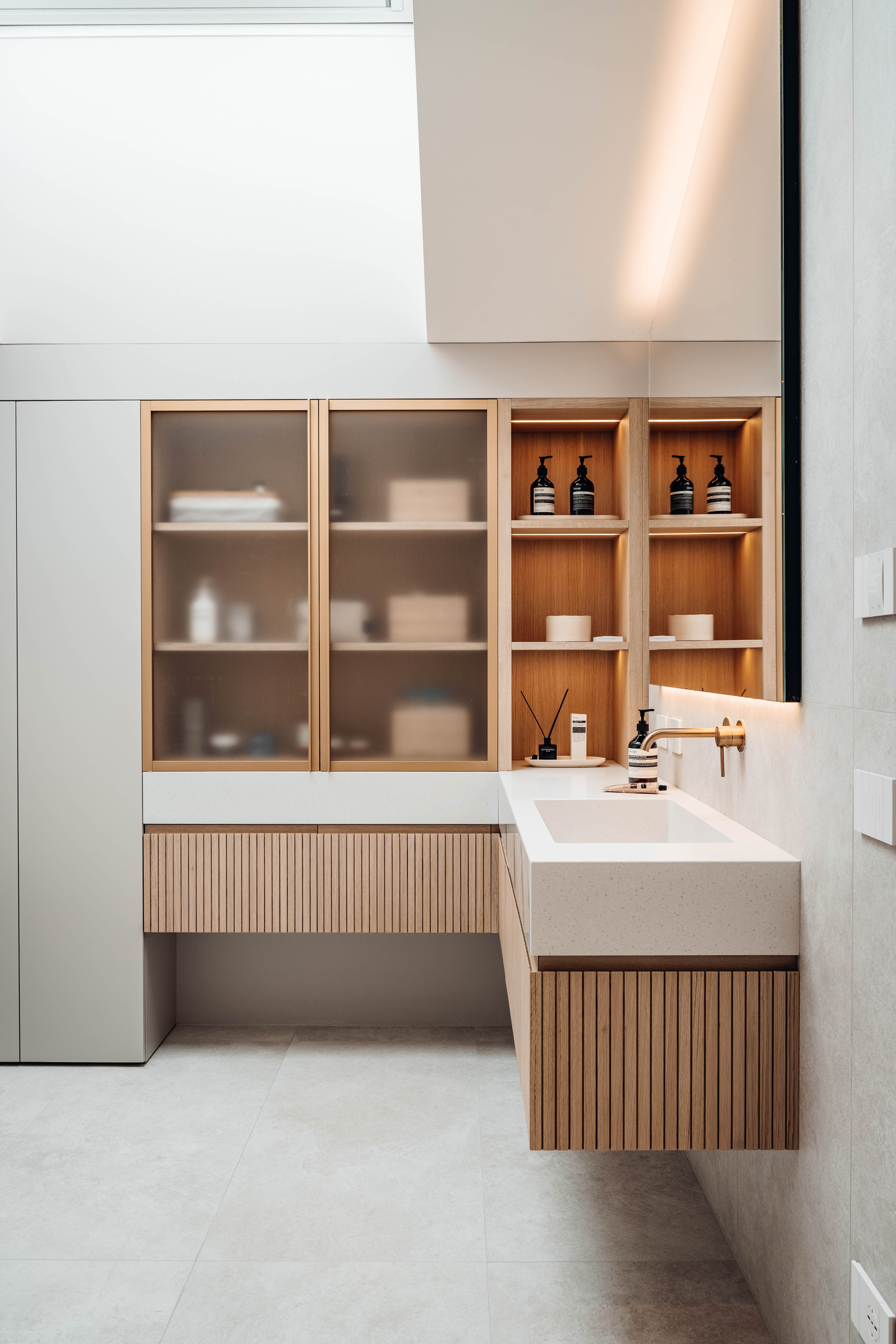 Bagno su misura Corazzolla con mobile lavabo in listelli di rovere e armadiatura con vetro satinato opaco