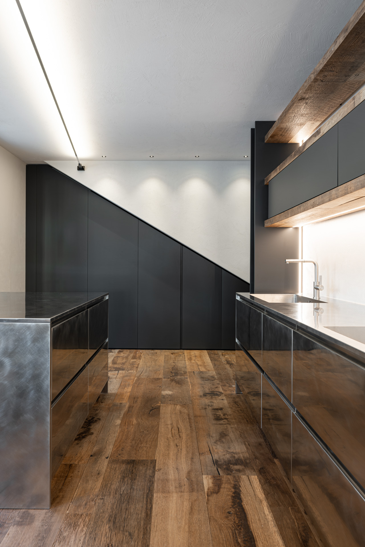 Cucina su misura in stile alpino con isola in acciaio inox realizzata da Corazzolla a Madonna di Campiglio