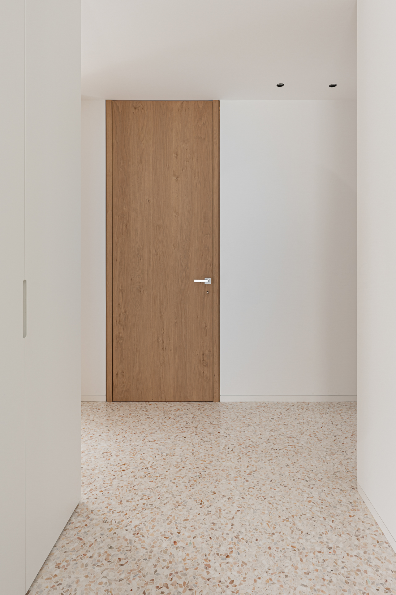 Porte in rovere a tutt’altezza a filo muro realizzate su misura da Corazzolla per interni minimal contemporanei.