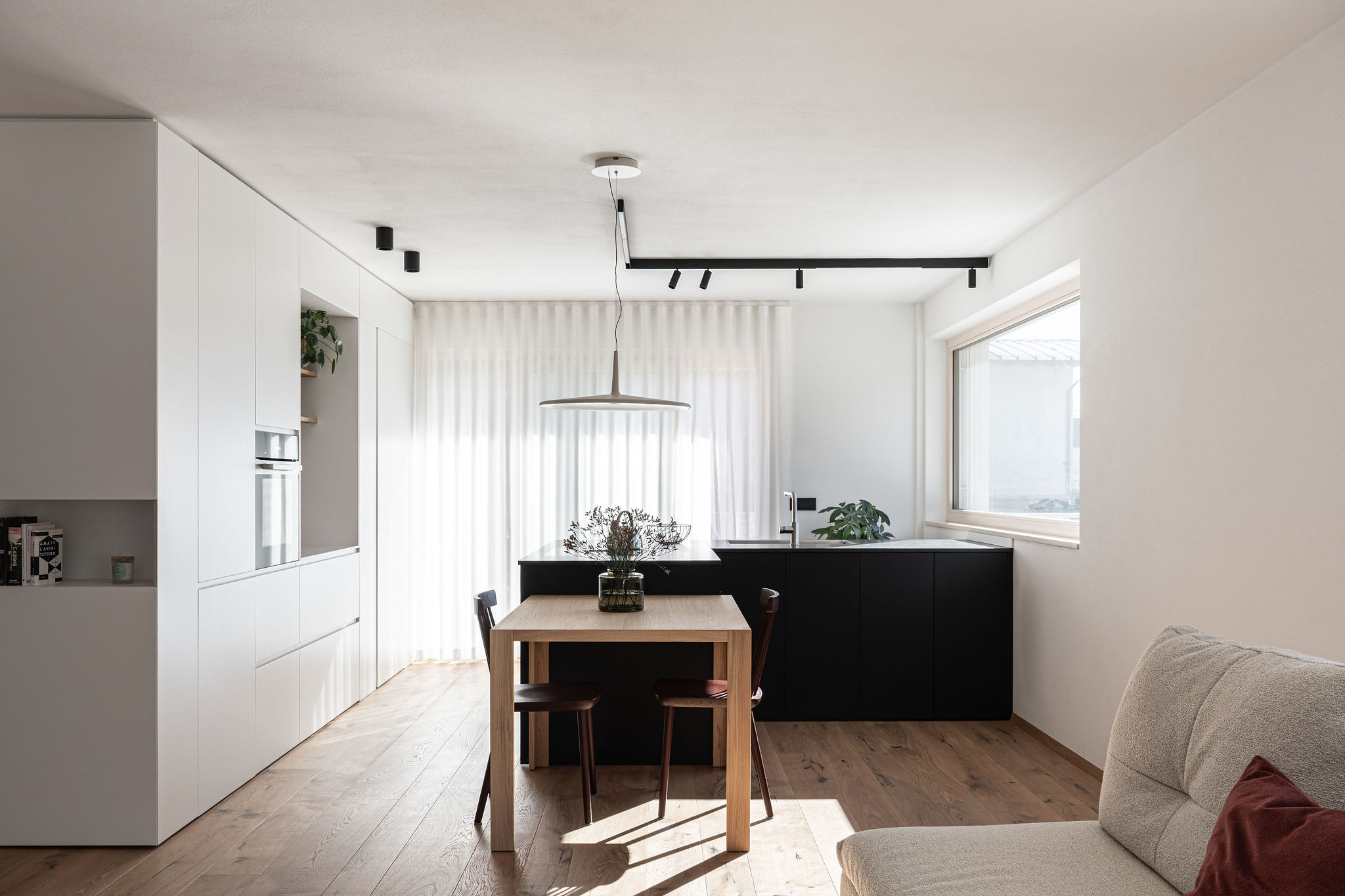 Cucina su misura minimale con isola a L nera, realizzata da Corazzolla