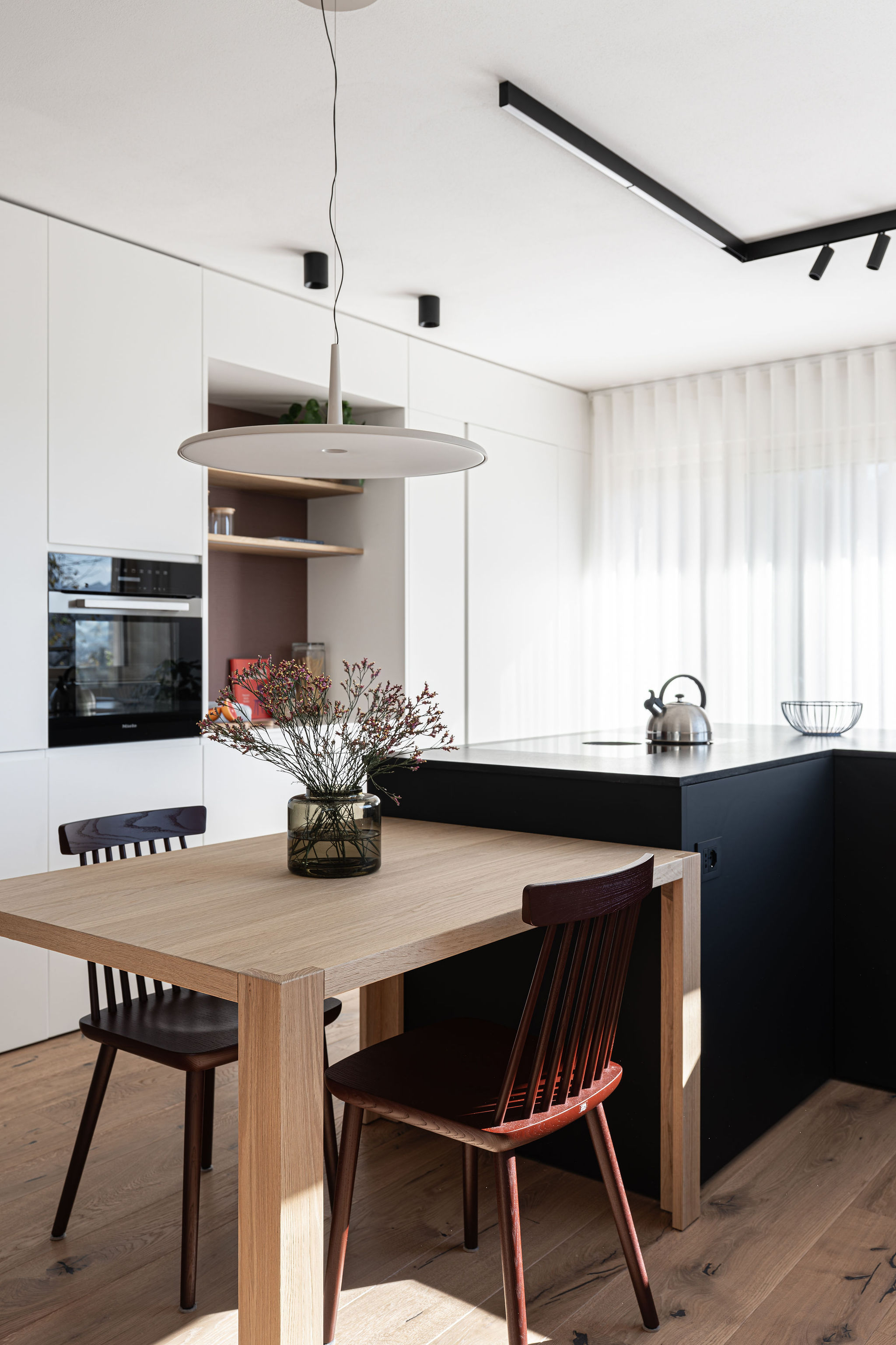 Cucina su misura minimale con isola a L nera, realizzata da Corazzolla