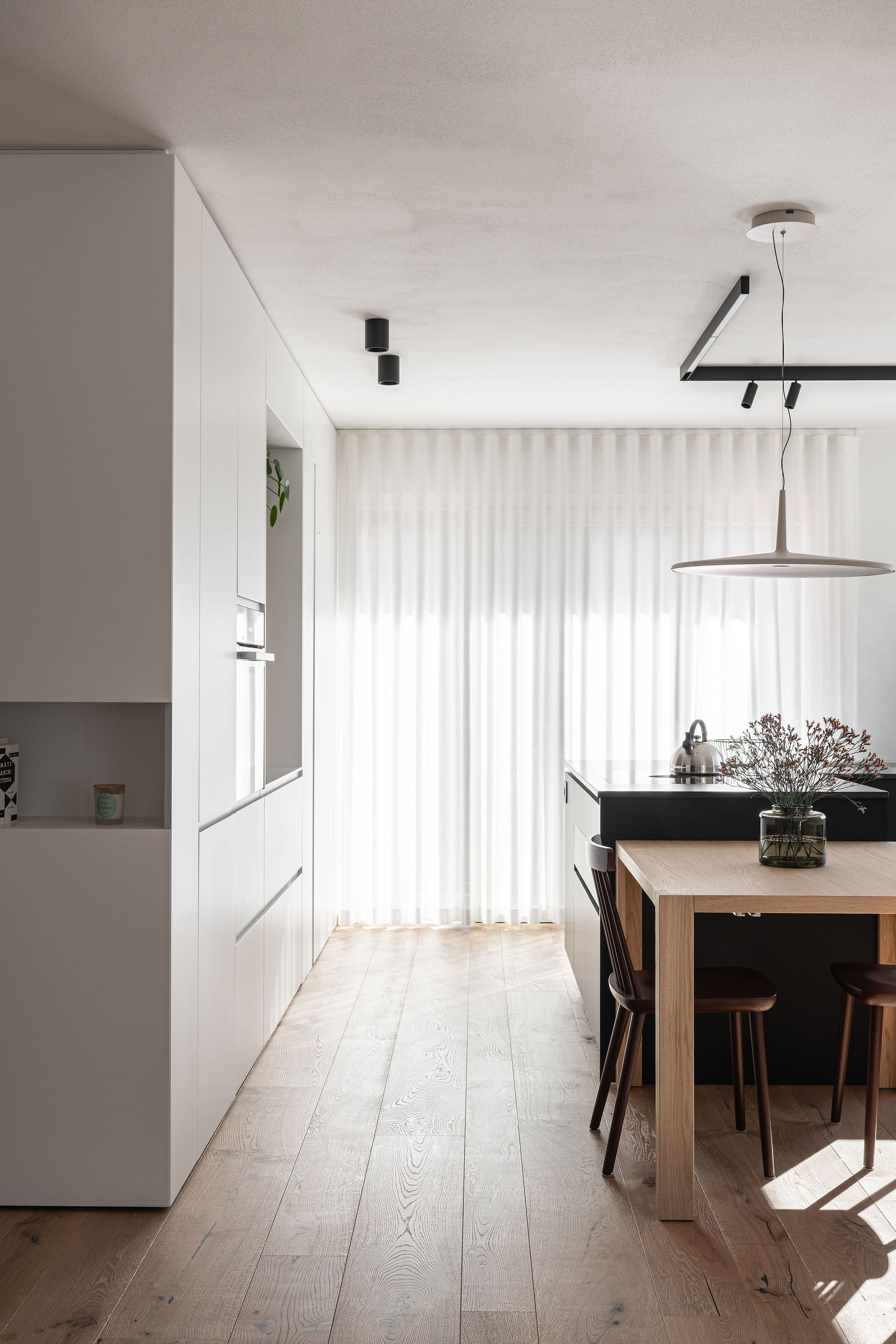 Cucina su misura minimale con isola a L nera, realizzata da Corazzolla