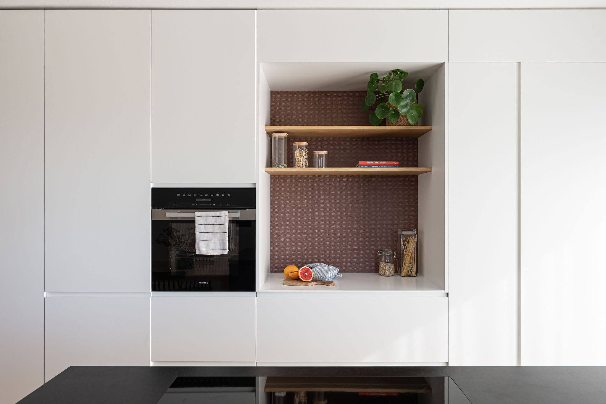 Cucina su misura minimale bianca con isola a L, realizzata da Corazzolla