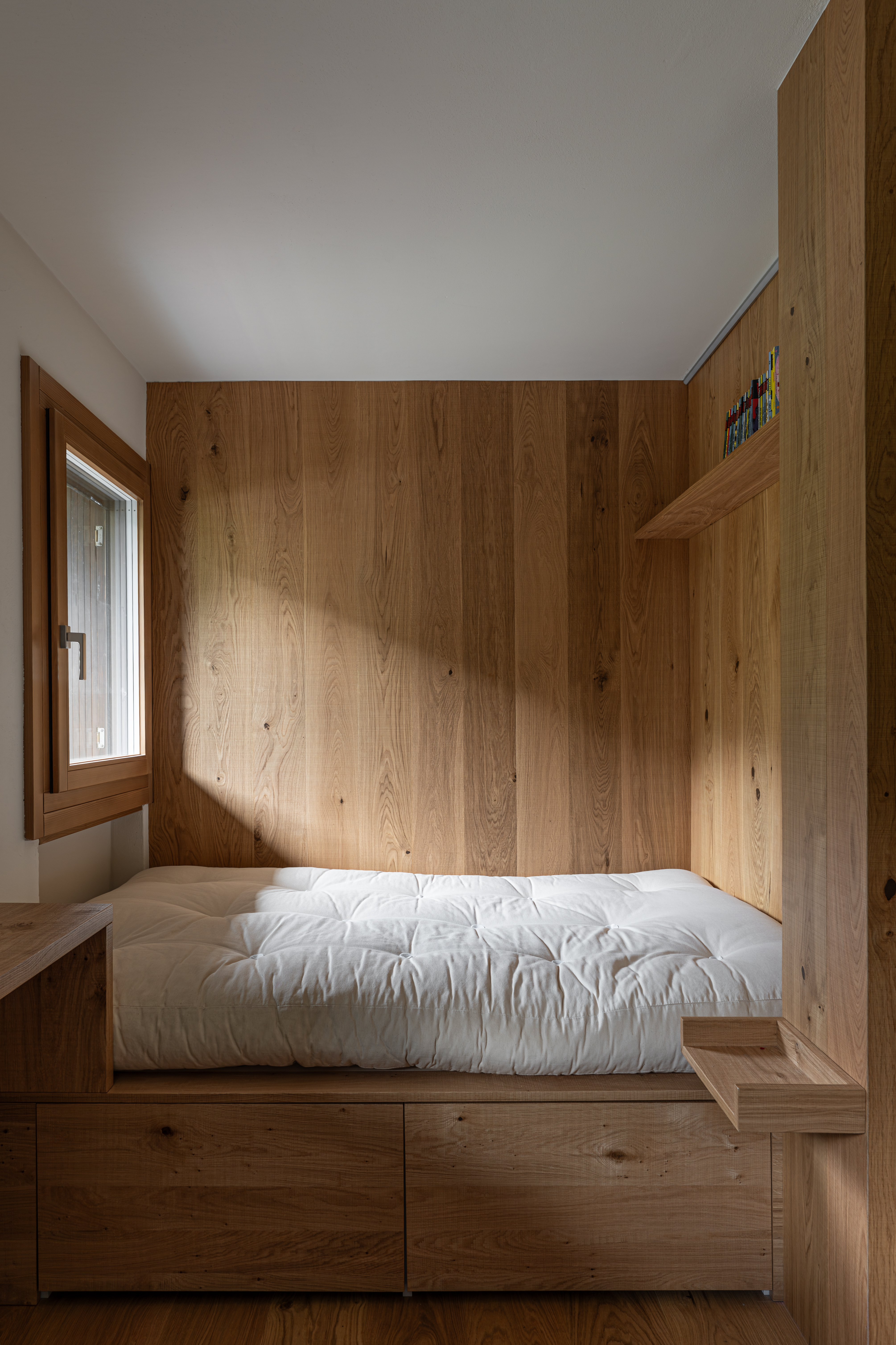camera da letto in stile alpino di montagna con letto e rivestimento in legno di rovere taglio sega, progetto e realizzazione di Corazzolla.